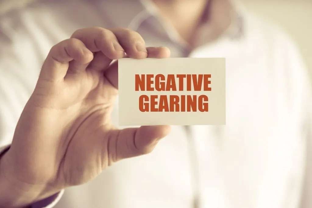 Person holding small card reading Negative Gearing