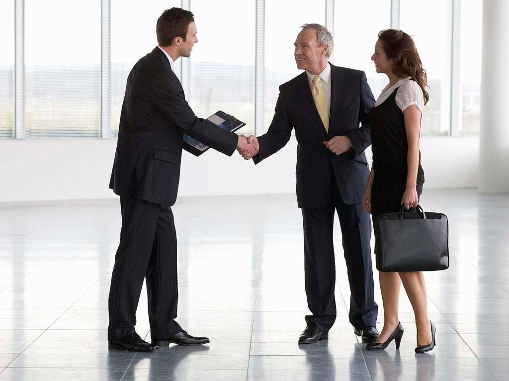 commercial property agent greeting business man and business woman