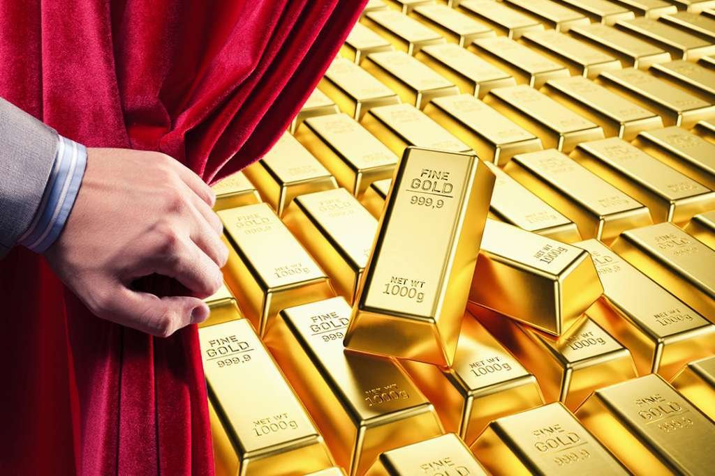 Hand opening curtain to reveal gold bullion